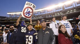 A fan holds up a sign commenting on the possible move by the San Diego Chargers to Los Angeles, Dec. 20, 2015.
