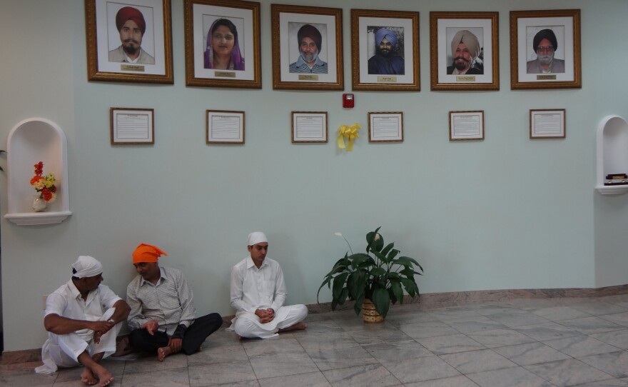 Framed photos of the six shooting victims of last August's shooting hang in the temple lobby.