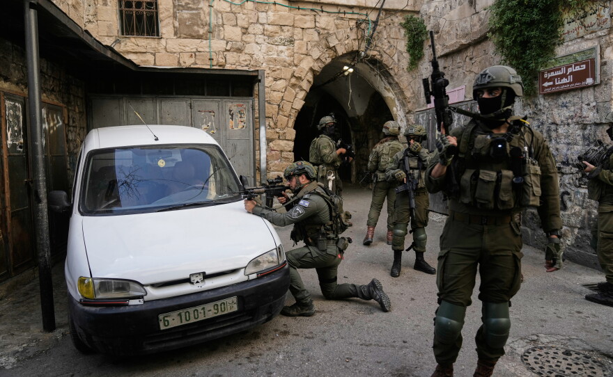 Israeli soldiers take up positions during an army raid in the West Bank town of Nablus, Feb. 11.