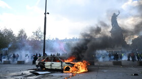 A car burns at Place de La Republique during a protest against rising living costs in Paris on Saturday.