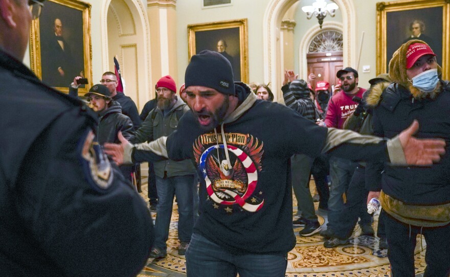 The congressional committee investigating the Jan. 6, 2021 attack on the Capitol will focus on the role of QAnon and extremist groups like the Oath Keepers and Proud Boys in its upcoming hearing. Prosecutors have identified the man at the center of this photograph as a QAnon-supporter named Douglas Jensen. Jensen has pleaded not guilty to all charges.