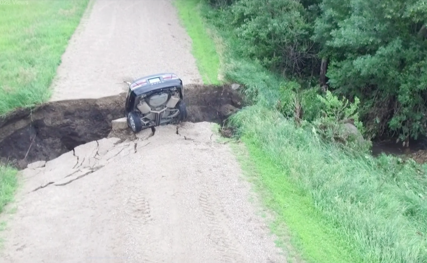 A screenshot from a video posted by the Renville County Sheriffs Office shows the aftermath of a car driving into a chasm in the road.