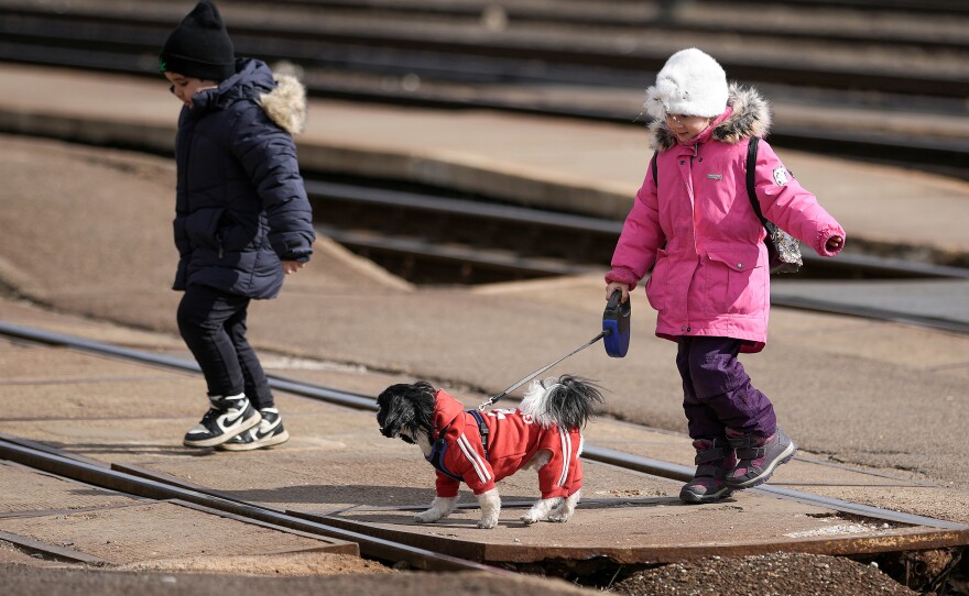 Two young refugees fleeing Ukraine arrive at the border train station of Zahony with a dog on March 10 in Zahony, Hungary. Hungary, one of Ukraine's neighboring countries, has welcomed more than 144,000 refugees fleeing Ukraine after Russia began a large-scale attack on Ukraine on Feb. 24.