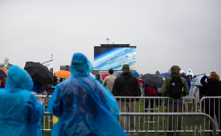 People gather to watch a presentation during the rally near the Washington Monument.