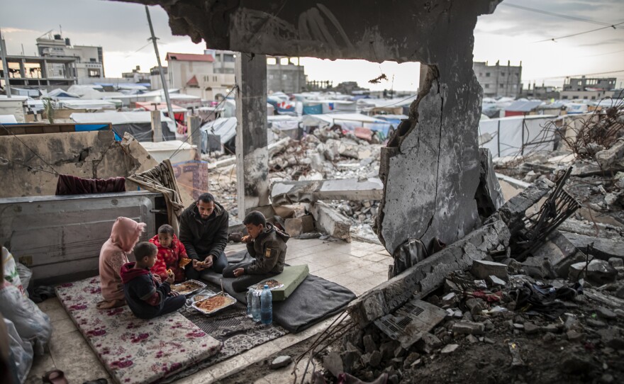 Palestinian Muhammad al-Durra, who lost his wife and whose house was destroyed in an Israeli attack, breaks his fast with his children during Ramadan in the wrecked house, in Rafah, March 20.