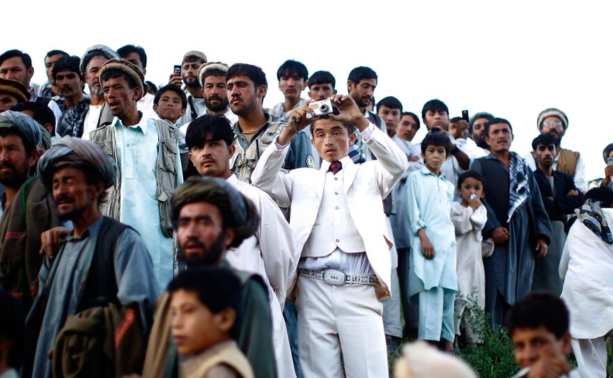 Afghan president Hamid Karzai held a rally in a remote village, where he struck a deal with an influential religious leader. Thousands gathered for the campaign event. From the story "Afghan President Karzai Rallies Support," 2009.