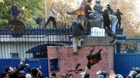 Protesters storm a security gate as they break in to the British Embassy during an anti-British demonstration in the Iranian capital on November 29, 2011 in Tehran, Iran. 