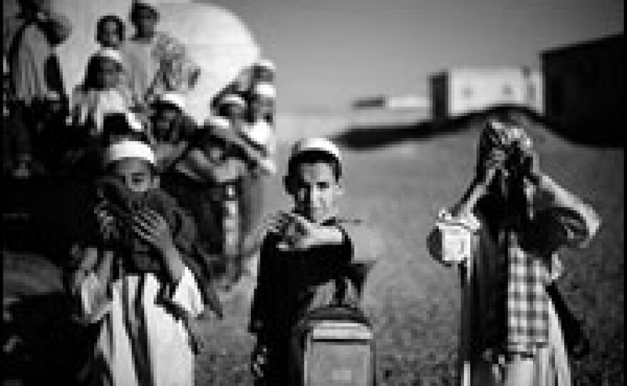 Afghan children leave their school building, which sits in the middle of a compound on the outskirts of Lashkar Gah. The school will be moved to make way for a new police training academy to be built by British and U.S. Provincial Reconstruction Teams.