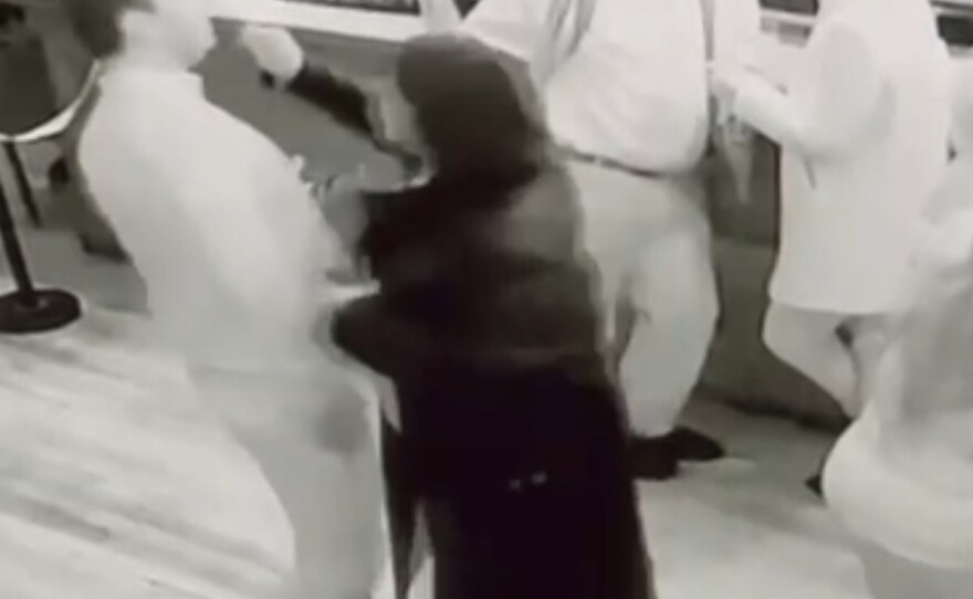 Rachi Messing says this still photo from security footage, provided by Messing, shows the incident in which Robert Cruz (in dark clothing) allegedly threatened his brother, Shimmy Messing, with a knife.