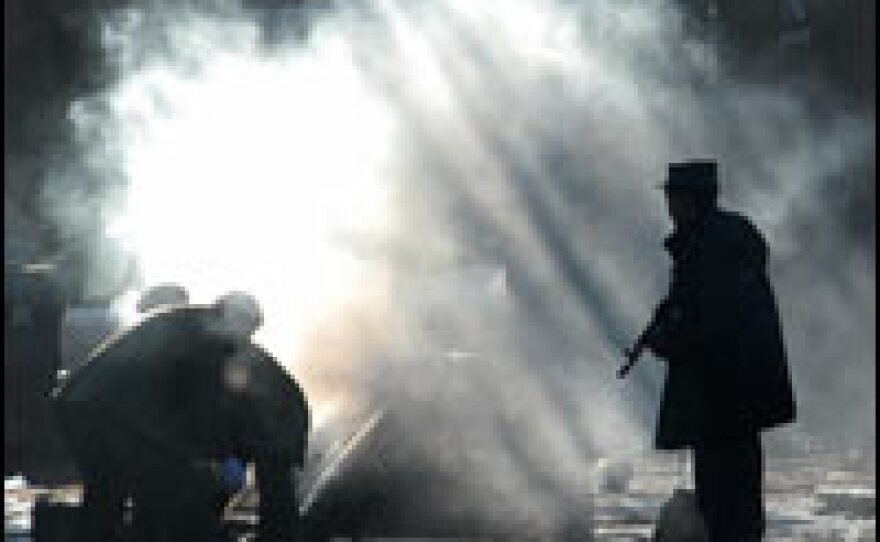 An Afghan soldier stands alert at the site of an explosion in Kabul on Dec. 15. An explosives-laden car was blown up outside the offices of the Kabul governor and city police headquarters, killing a number of civilians.