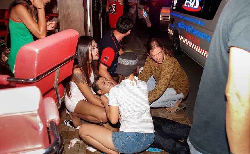 People help an injured man after twin bombs exploded in the upscale resort of Hua Hin, Thailand, on Thursday.