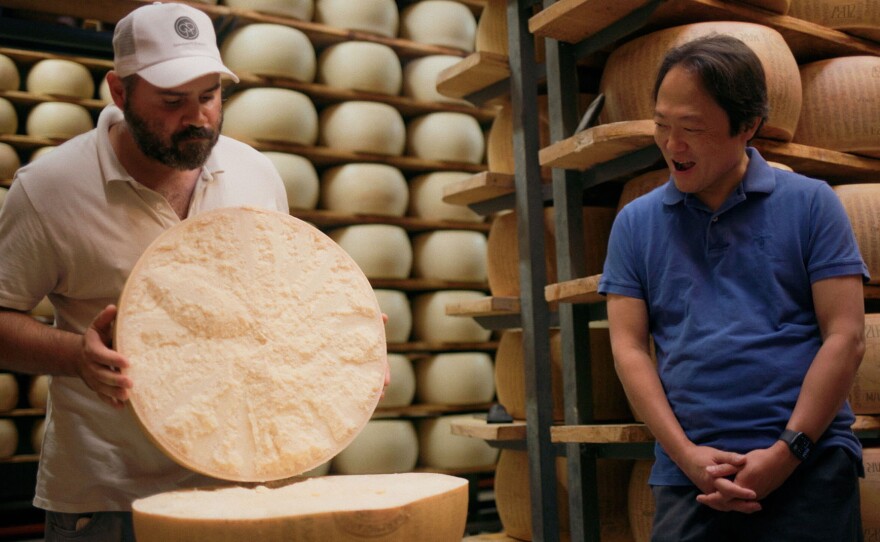 Scott Yoo with a cheesemaker in Parma, Italy.