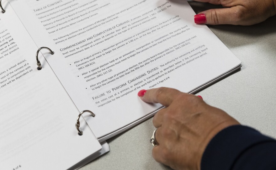 Former member of the Genesee County Board of Canvassers and republican, Michelle Voorheis, points to the official Manual for Boards of County Canvassers.