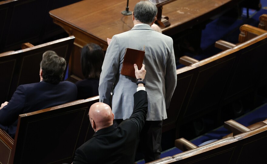 Rep.-elect Clay Higgins (R-LA) (R) puts a Bible on the back of Rep.-elect Andrew Clyde (R-GA) as he votes for House Republican Leader Kevin McCarthy (R-CA).