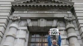 Karen Shore holds up a sign outside of the 9th U.S. Circuit Court of Appeals in San Francisco, Tuesday, Feb. 7, 2017.