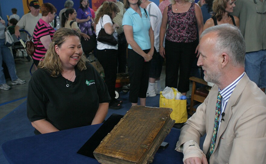 Stephen C. Massey (right) appraises a 1586 Mattioli German ed. "Herbal" book in Reno, Nev.