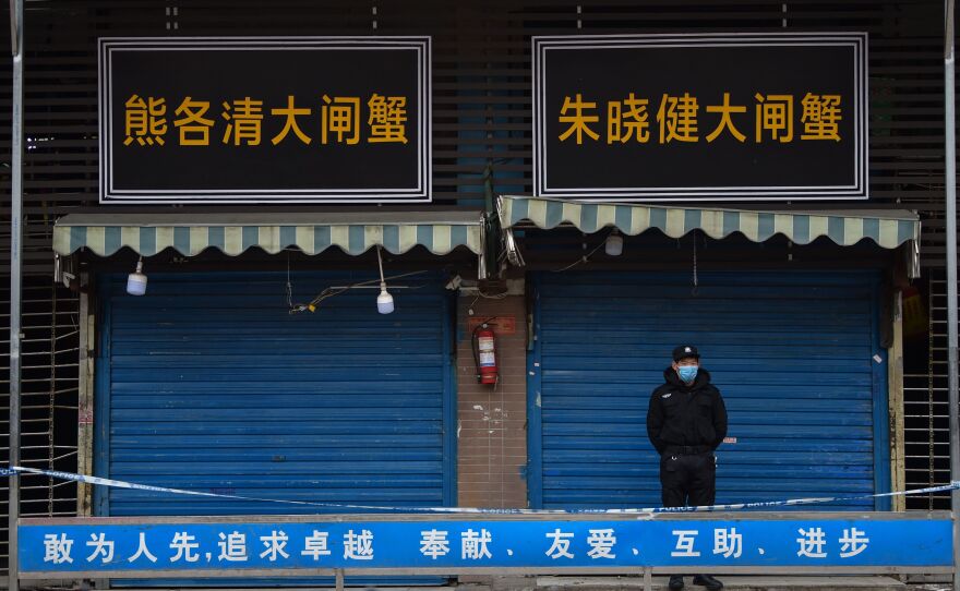 A security guard stands outside the Huanan Seafood Wholesale Market, where the novel coronavirus was detected in Wuhan, China.