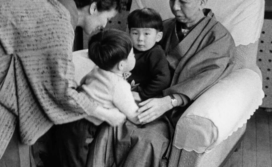 A family picture of Nobusuke Kishi, then-prime minister of Japan, and his wife Ryoko in a kimono, with their grandsons Shinzo Abe and Hironobu Abe (on his grandfather's lap). The photo is undated but is probably taken in the 1960s, likely in the prime minister's official residence in Tokyo.