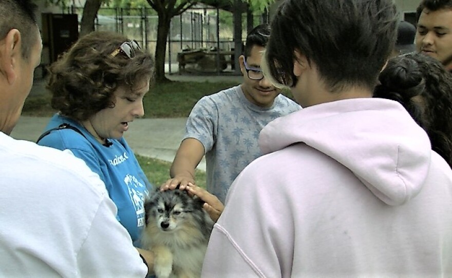 Pet Encounter Therapy Program manager Robin Cohen holds her dog, Balonee, while students pet him, May 31, 2017.