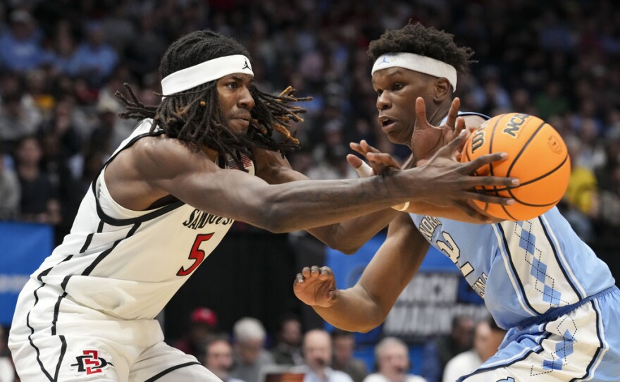San Diego State forward Pharaoh Compton (5) passes against North Carolina forward Ven-Allen Lubin (22) during the first half of a First Four college basketball game in the NCAA Tournament, Tuesday, March 18, 2025, in Dayton, Ohio.