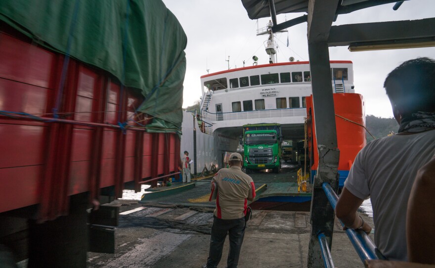 Ferry employees guide trucks off the ferry in Lembar, a port on Lombok.