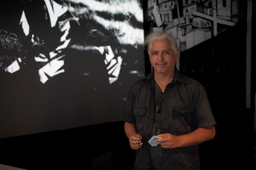 Artist Hugo Crosthwaite is shown in an undated photo working on his installation, "The Rupture of the White Cube," at Mesa College Art Gallery.