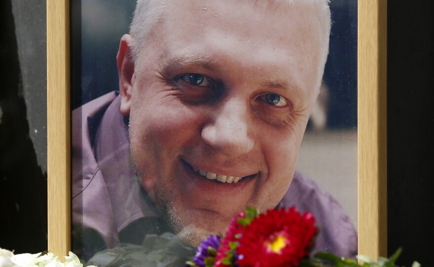 A portrait of journalist Pavel Sheremet is surrounded with flowers and candles near where the car he was driving exploded, killing him on Wednesday.