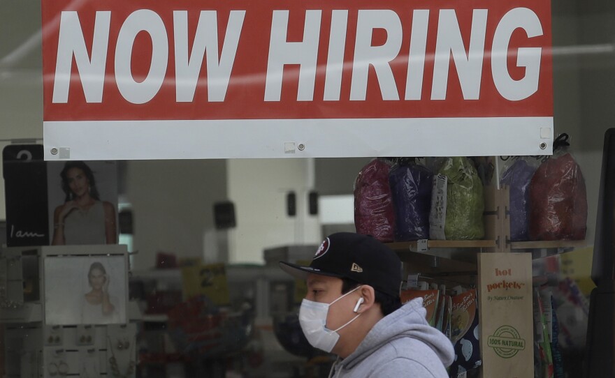 A man walks by a CVS Pharmacy in San Francisco on May 7. U.S. employers unexpectedly added jobs last month as the unemployment rate fell.