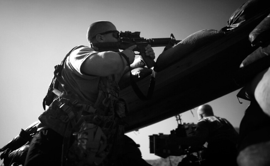 PFC Thomas Packer from Tama, Iowa, looks through the scope on his rifle as incoming mortar rounds hit just outside the bunker at Combat Outpost Wilderness in Paktia province.