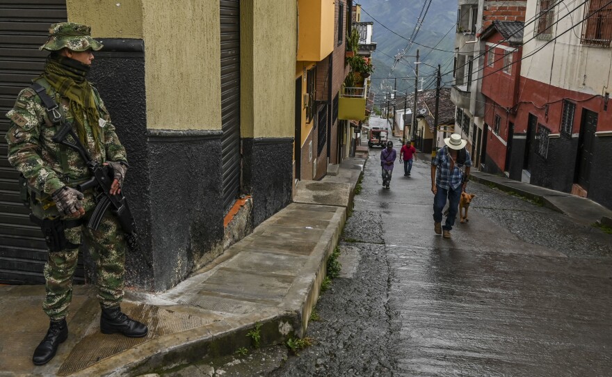 A soldier stands guard on a street in Ituango, Colombia, on Oct. 19, 2019. The town is home to a new public radio station staffed by ex-FARC rebels and war victims. Reporters often conduct interviews with former combatants and update listeners on the progress and setbacks of Colombia's peace accords.