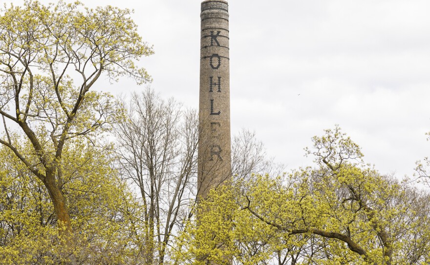 Part of the Kohler factory peeks over homes in the small town of Kohler, Wis. The two-tiered wage scale at the company became a rallying cry, as veteran workers joined the fight to boost pay for their newer colleagues.