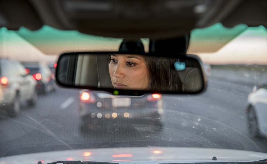 Thao Ha, who grew up in Houston and now teaches sociology at a college in California, drives in traffic as she tells NPR reporters about life in Houston's Little Saigon.