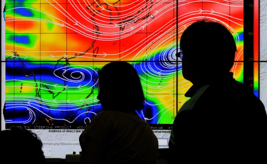 Meteorologists from the Philippine Atmospheric, Geophysical and Astronomical Services Administration (PAGASA) monitor and plot the direction of super typhoon Hagupit on Thursday at their office in suburban Manila.