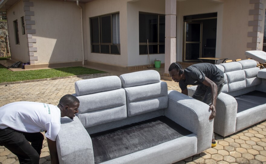 People carry furniture into one of the locations expected to house some of the asylum-seekers due to be sent from Britain to Rwanda, in the capital Kigali, Rwanda on May 19, 2022.