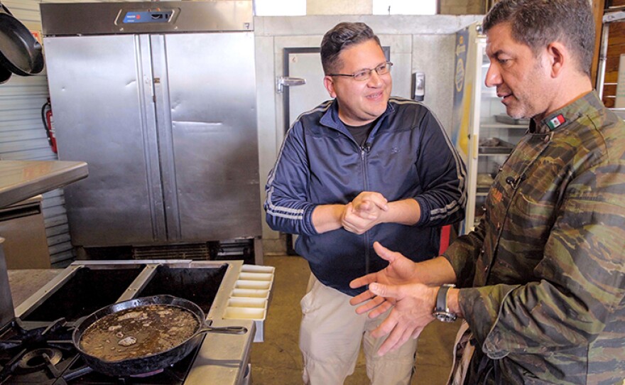 Host Jorge Meraz learns cooking tips with chef Miguel Angel at La Esperanza restaurant. Valle de Guadalupe, Baja Calif.