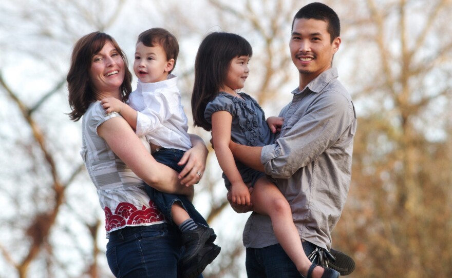 Jeannine Sato holds her 2-year-old son, Keni; 5-year-old Hana is held by her father, Mas Sato. Jeannine decided to leave her job when her employers said she could take six weeks off after giving birth to her first child or risk losing her job.