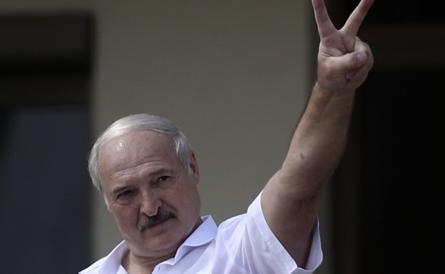 Belarus' President Alexander Lukashenko shows the V-sign during a rally of his supporters in Independence Square last year.