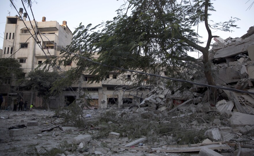 Palestinians check on Tuesday the damage of a building destroyed by Israeli airstrikes in Gaza City.