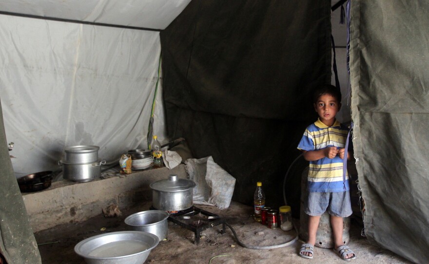 An Iraqi boy, whose family fled Ramadi after it was seized by the self-declared Islamic State, is now living in a tent camp for displaced families near the capital Baghdad. Many civilians fled the city and government forces are now attempting to regroup.