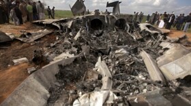 Libyans gather around a U.S. F-15 fighter jet after crashing while on a mission against Gadhafi's defences.