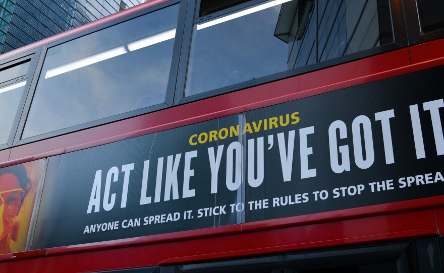 Moderna will test new COVID-19 vaccine boosters, saying that while its vaccine should protect against variants found in the U.K. and South Africa, it isn't as effective against one strain.  Here, a bus in London carries a sign telling people, "Act Like You've Got It" — to prevent the coronavirus from spreading.