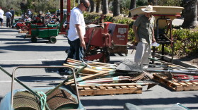 Restaurant owner Leo Ruiz, center, looks over garden equipment prior to the San Luis Rey Downs Golf Course auction. Sept.25, 2014

