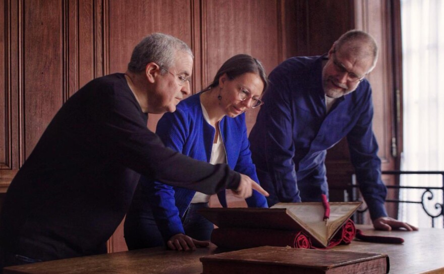 Codebreakers George Lasry and Norbert Biermann inspect the original letters of Mary, Queen of Scots with a representative at the National Library of France.