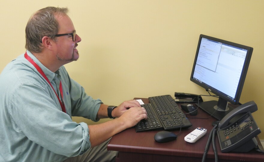English Professor Neal Phillips sits at a Valencia campus computer in Orlando, Fla., crafting an email blast to students who've been flagged by a new program that analyzes how they're performing.