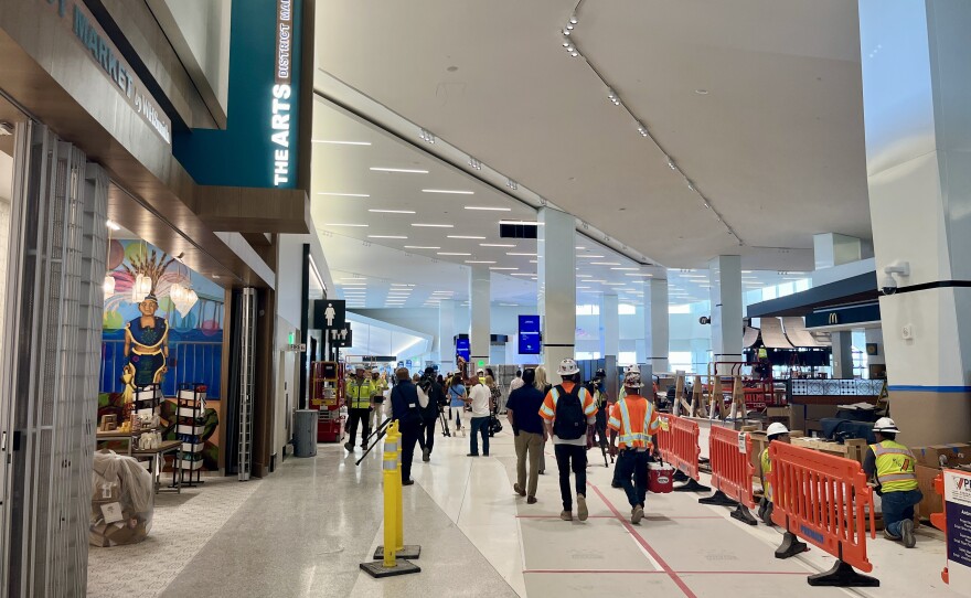 Construction crews and members of the media walk around inside San Diego International Airport's New Terminal 1, Aug. 27, 2025.
