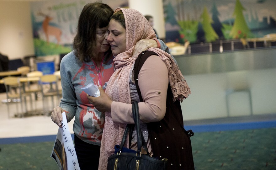 Geri Berg (left), a pediatric social worker who helped bring Mustafa to the U.S., hugs Mustafa's mother, Nidhal Aswad at the airport. Nidhal is concerned about the short supply of clean water needed to keep his colostomy free of infection near Mustafa's home in rural Iraq.