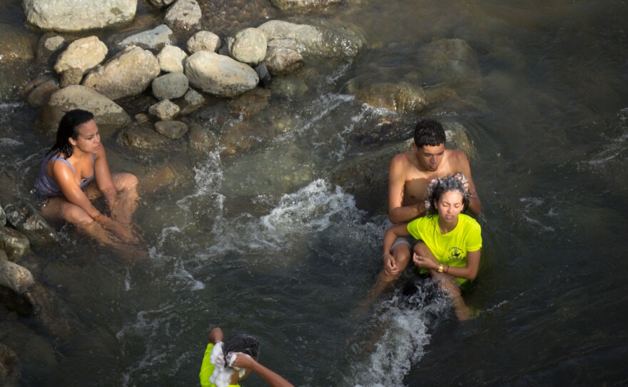 One teenager says washing up in the Calabaza River beats trying to do so in a house where the taps are dry. "You have to take a bath with cups," he says. "And it's so cold. You can't waste gas on making it warm."