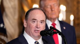 Secretary of the Navy John Phelan speaks, as President Trump listens, at Trump's Mar-a-Lago club on Dec. 22 in Palm Beach, Fla.