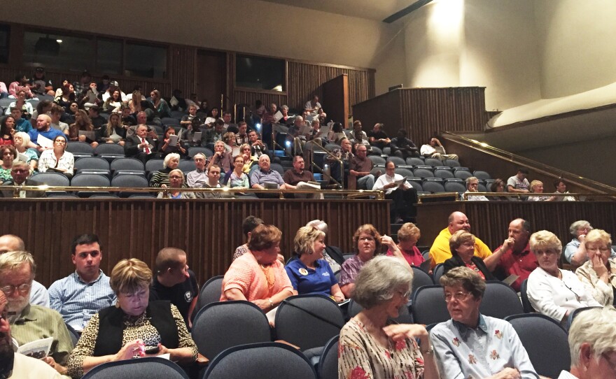 A few hundred people gather in an auditorium at Hutchinson Community College in Hutchinson, Kan., to watch the state Supreme Court hear oral arguments.