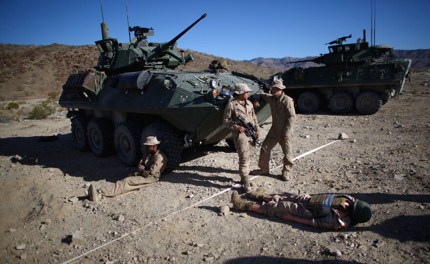 Marines wait with Carl, a 220-pound dummy that acts as a stand-in for a wounded Marine during the exercise.